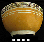 Hemispherical bowl with orange solid color field slip with inlaid rouletting - from 18BC79.